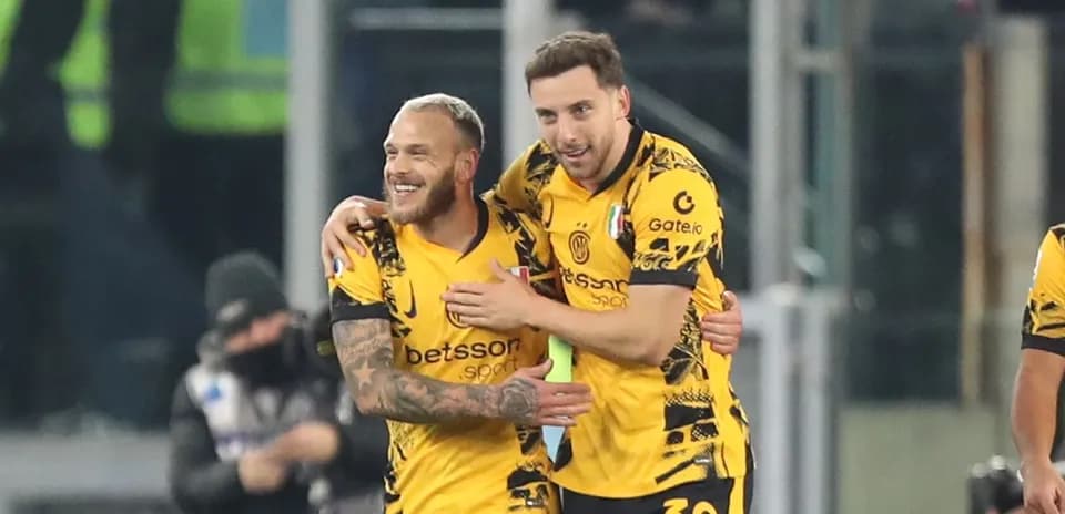 Two players celebrating a goal in yellow jerseys
