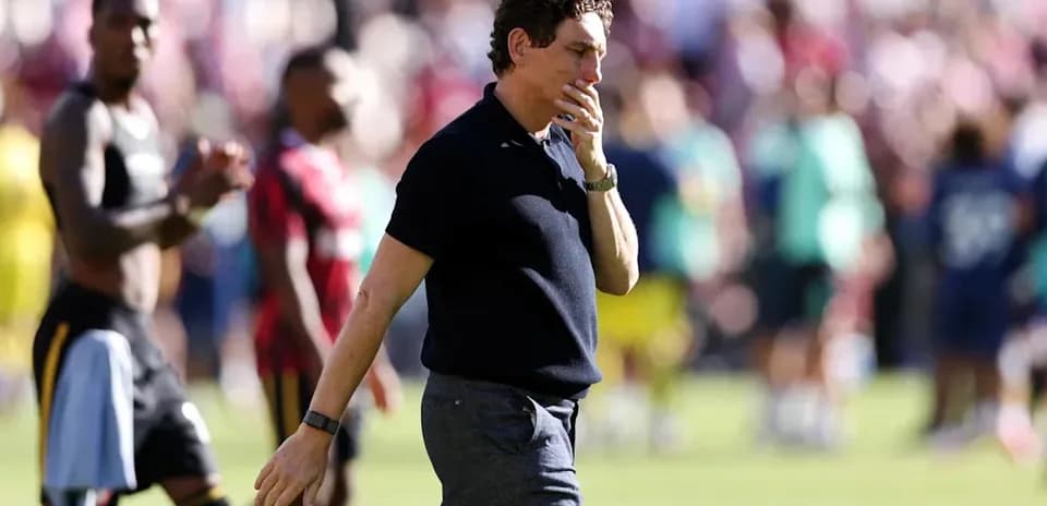 Coach walking past players after the match