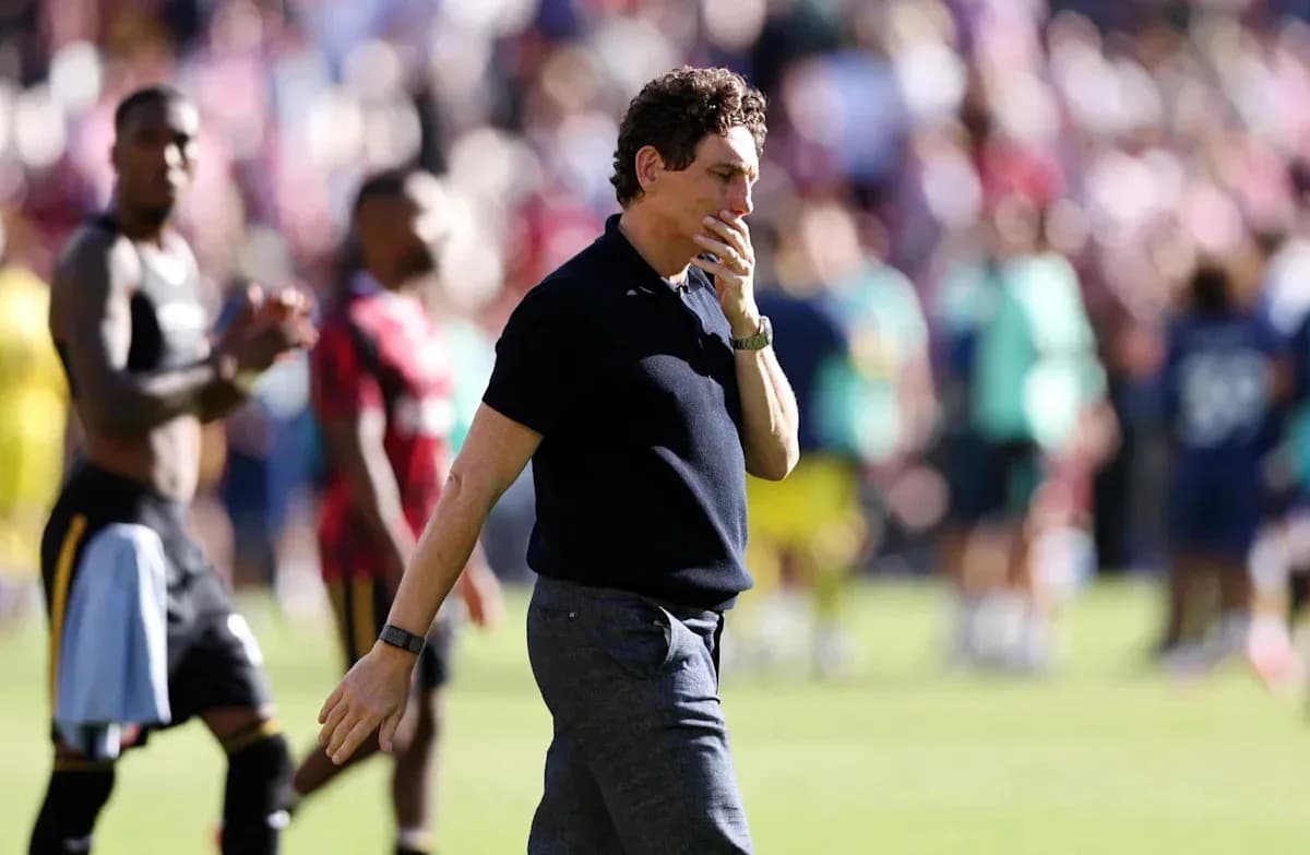 Coach walking past players after the match