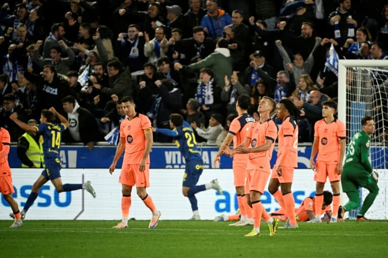 Players in orange jerseys reacting during match celebration