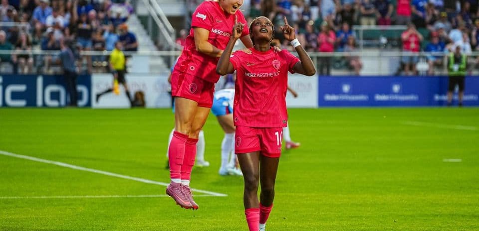 Players celebrating a goal during NWSL match