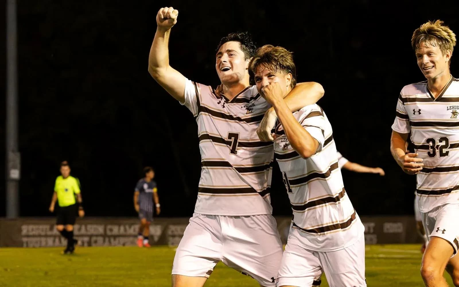 Two soccer players celebrating a goal on field