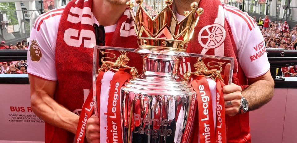 Two players celebrating with Premier League trophy