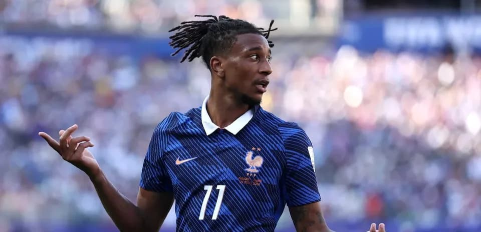 Player in blue France jersey gesturing on field