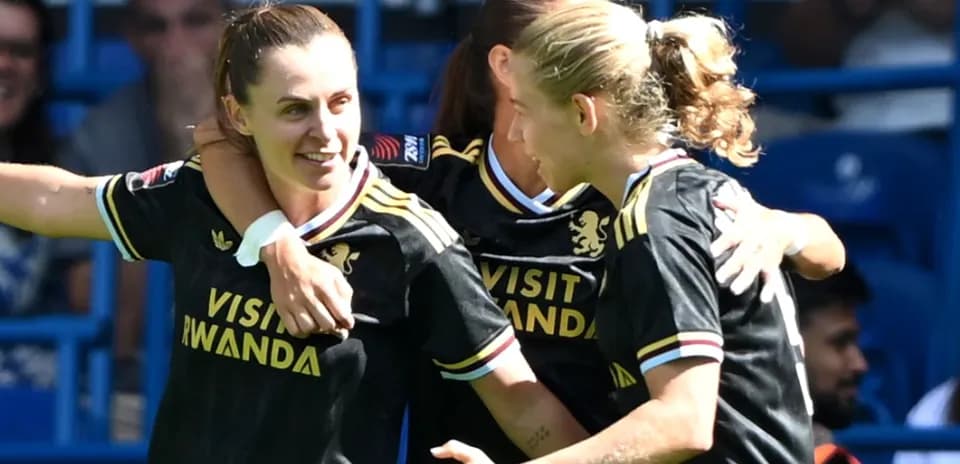 Three players celebrating a goal in team jerseys