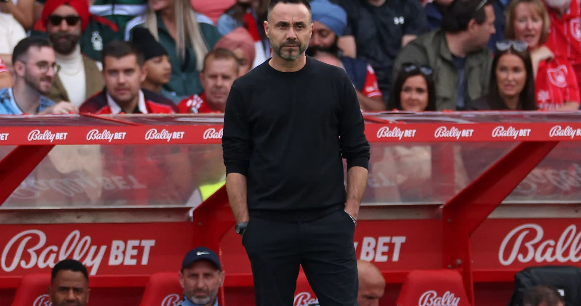 Coach standing on the sideline during match