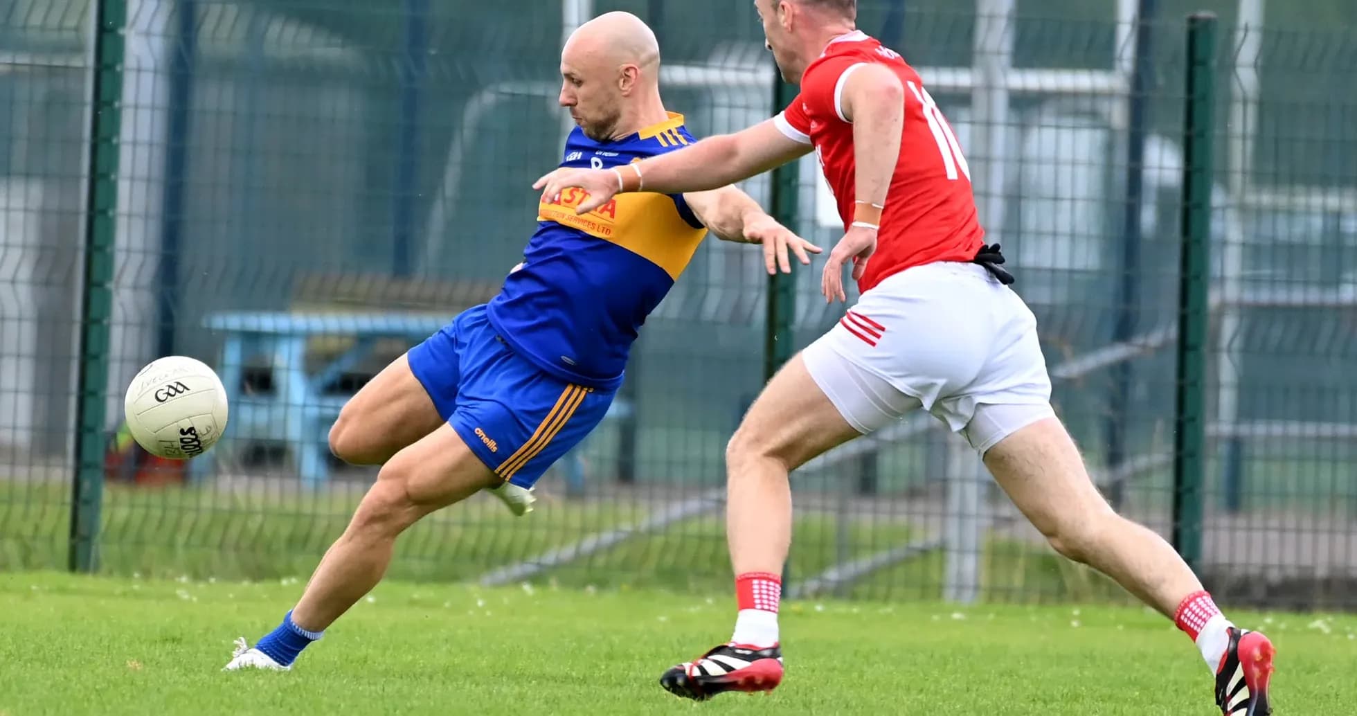 Player in blue tackling opponent in red during match