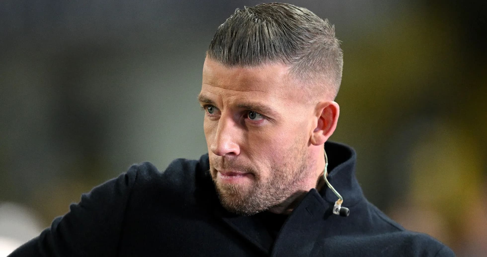Man with short hair wearing black coat