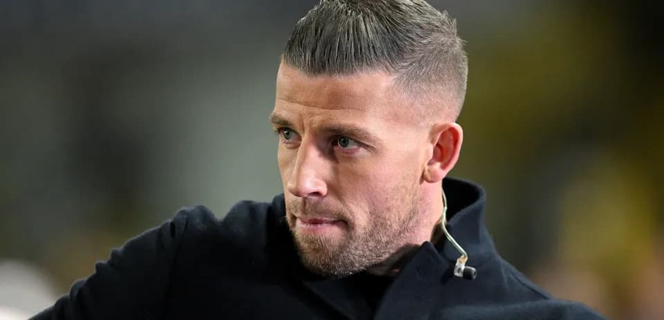 Man with short hair wearing black coat