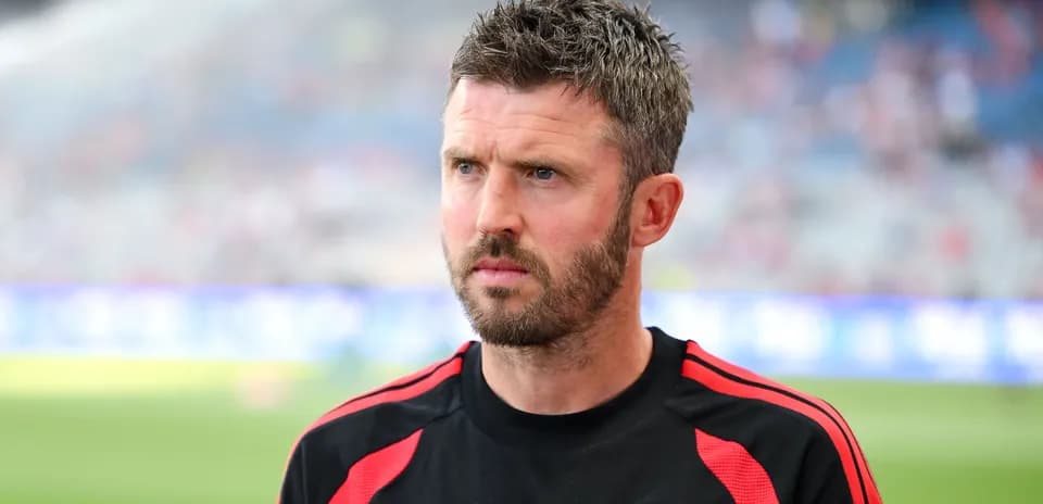 Coach wearing Manchester United training gear on pitch