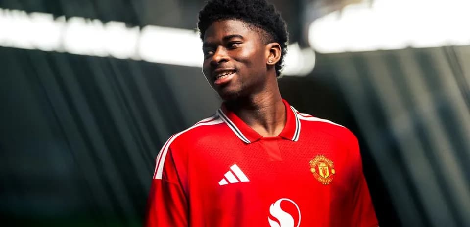 Player wearing Manchester United jersey smiling