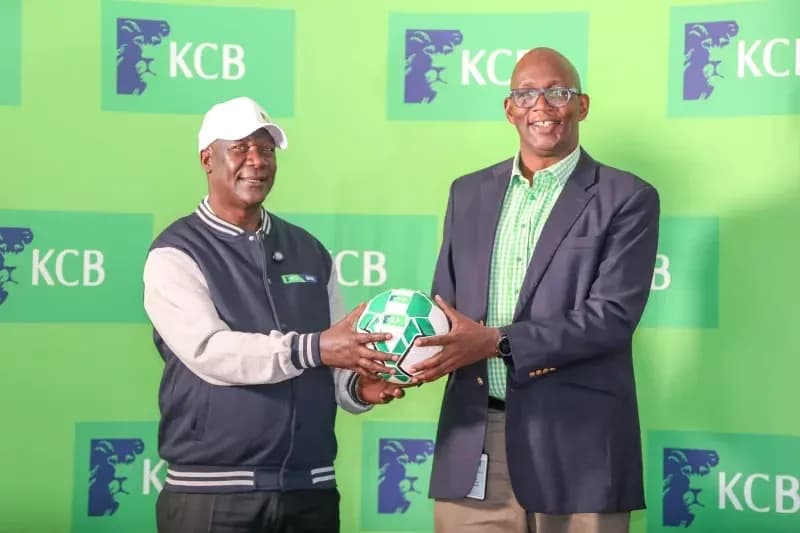 Two men holding a soccer ball at KCB event