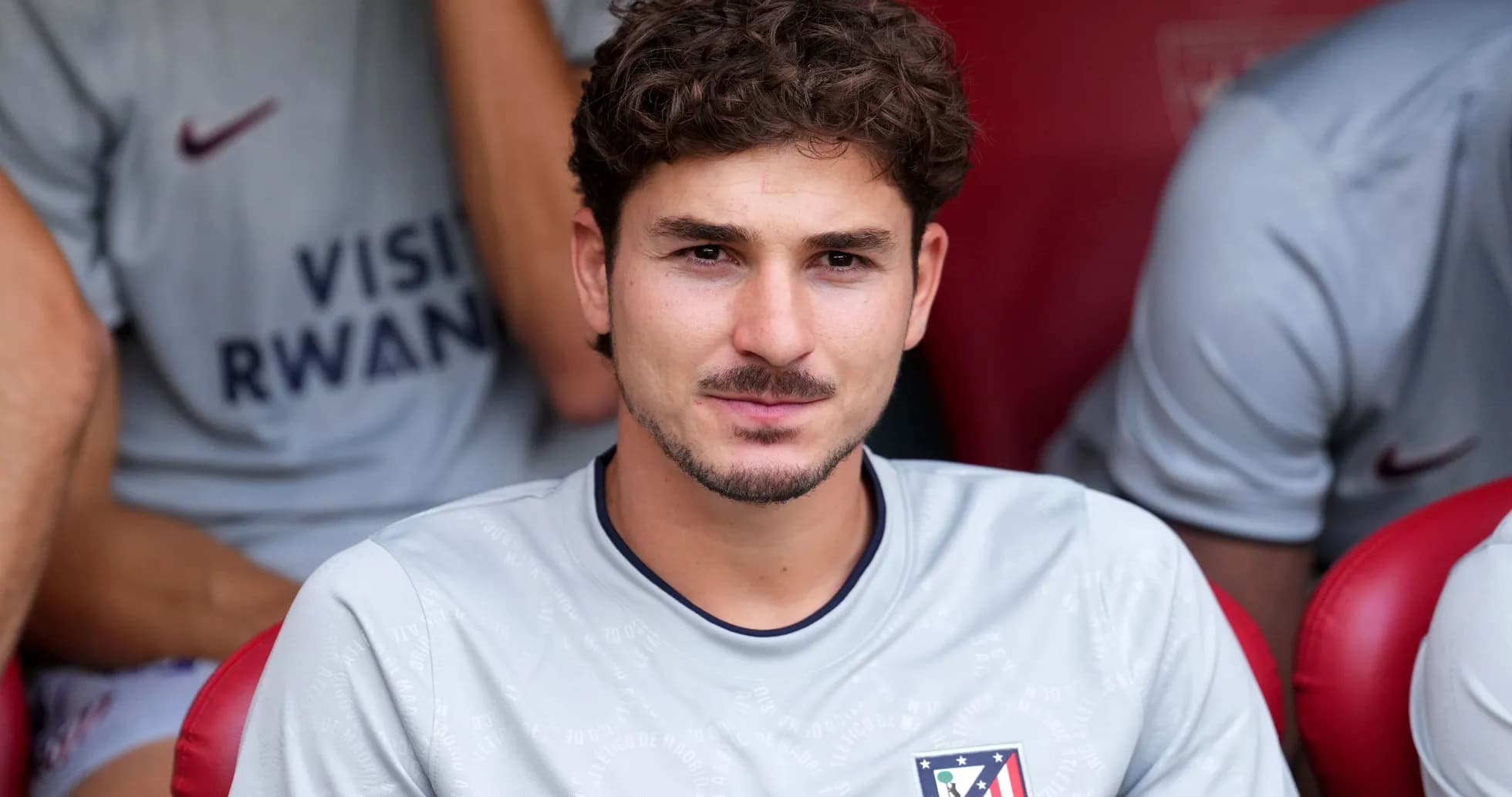Player sitting on bench in Atlético Madrid kit