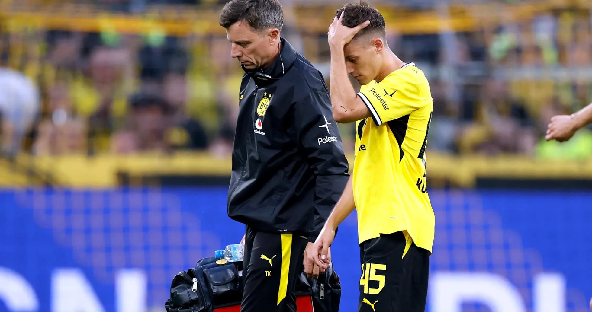 Player receiving assistance from staff after injury