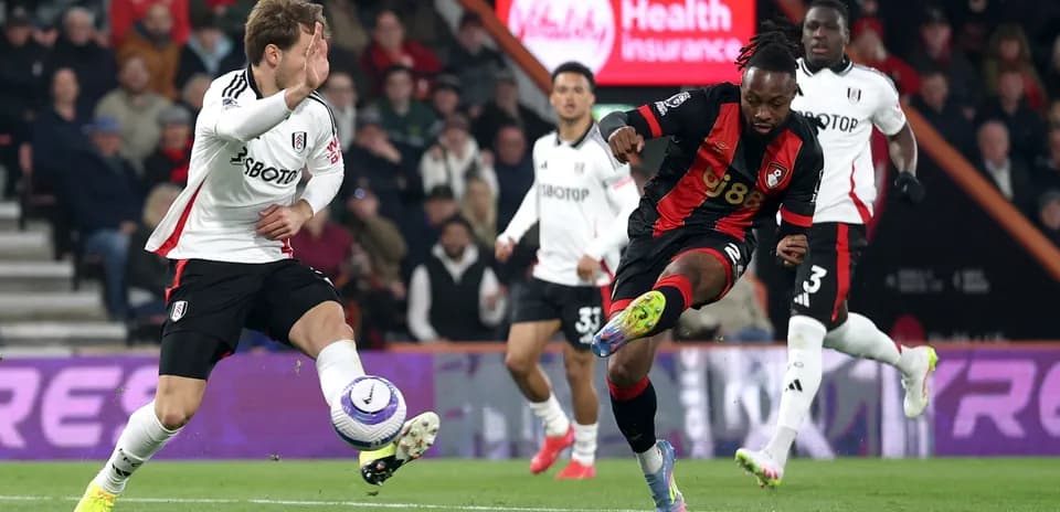 Fulham player challenging Bournemouth forward
