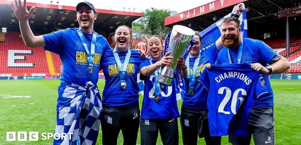 Celebrating team holding trophy and banners on field