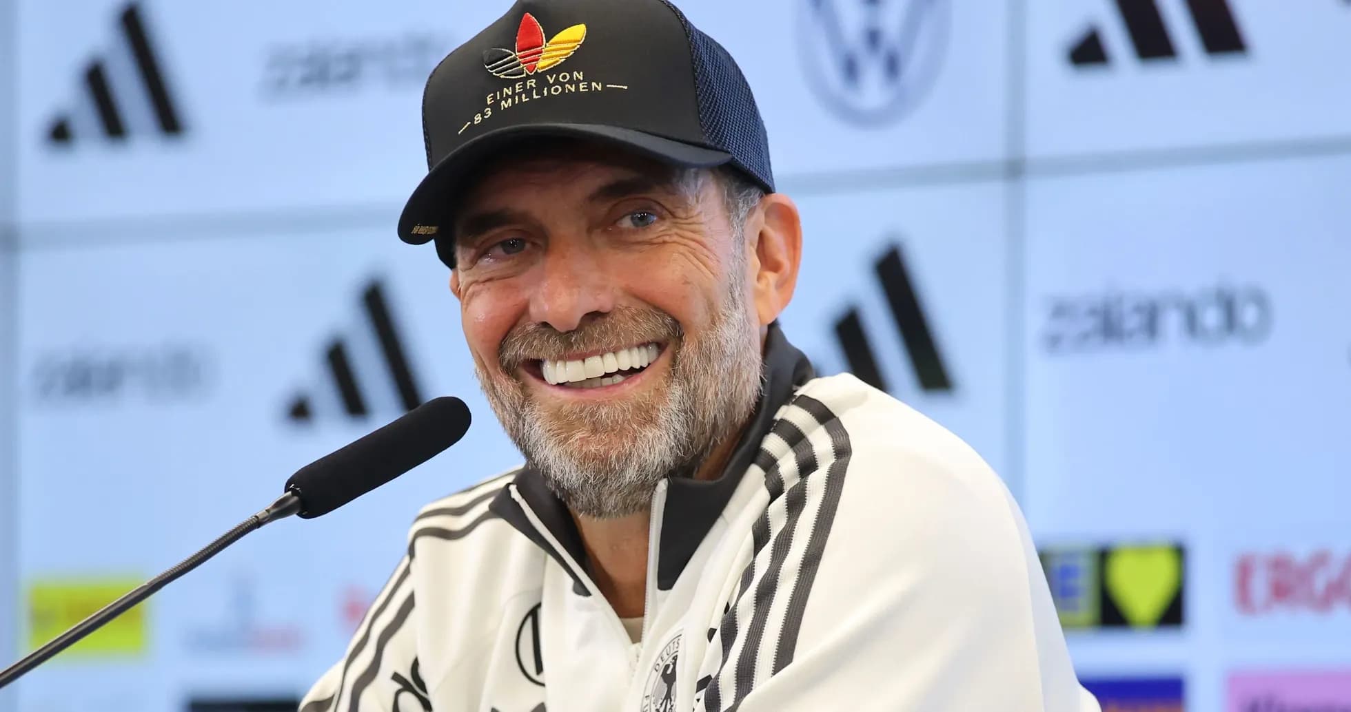 Coach smiling at press conference with microphone