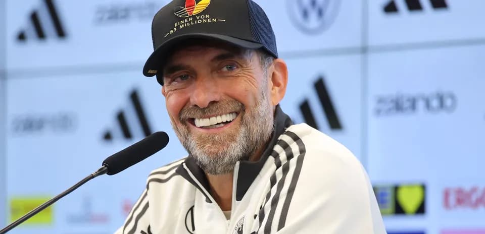 Coach smiling at press conference with microphone