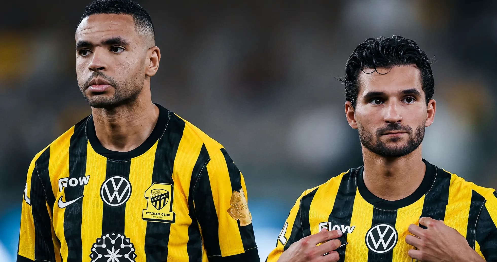 Two players wearing black and yellow uniforms standing together