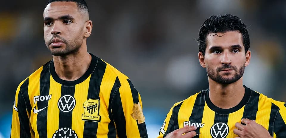 Two players wearing black and yellow uniforms standing together