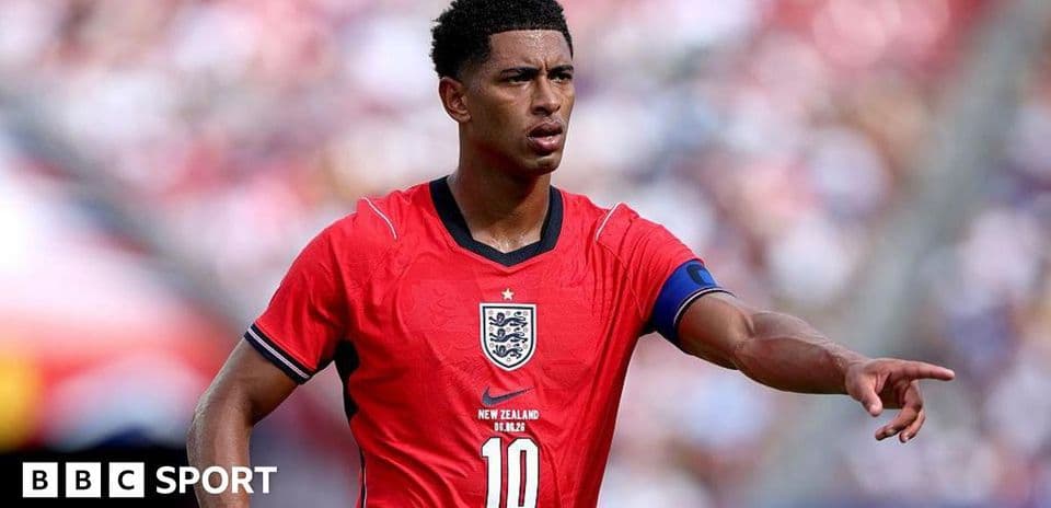 Player in red England jersey directing teammates on field