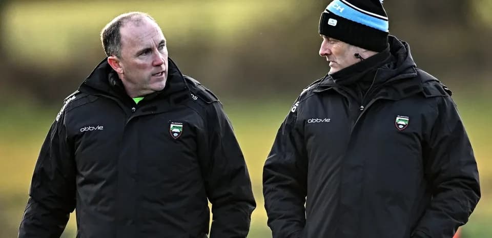 Two coaches discussing strategy during training session