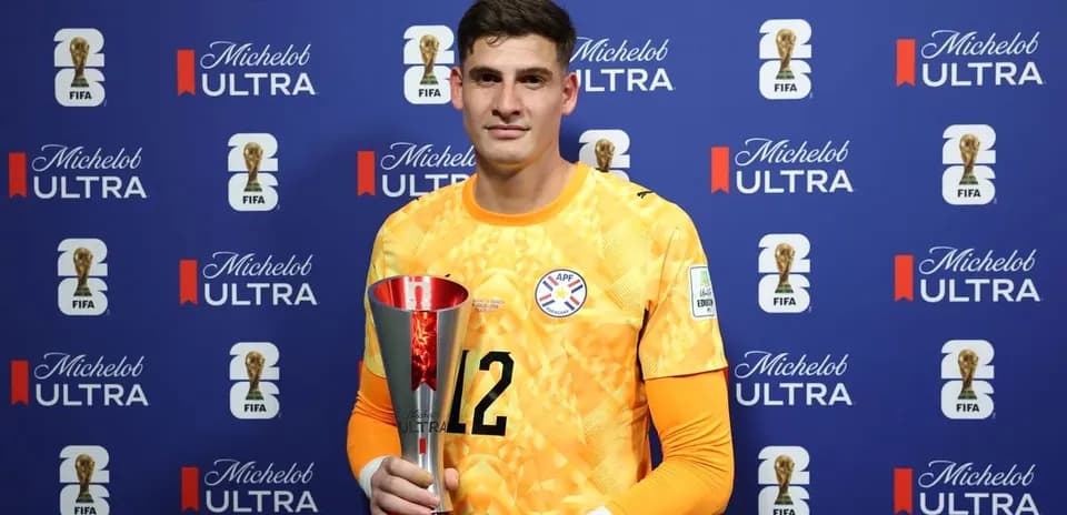 Goalkeeper holding trophy at FIFA event backdrop