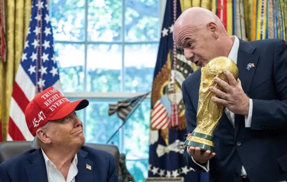 Man holding World Cup trophy with another man