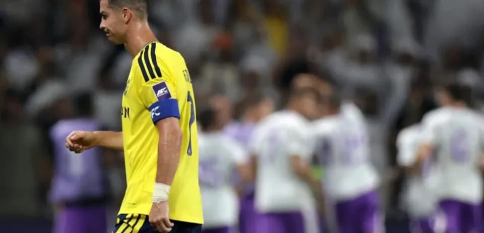 Player in yellow jersey walking past celebrating teammates