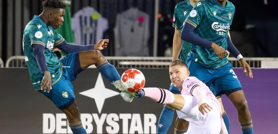 Player tackling goalkeeper during Vancouver FC match