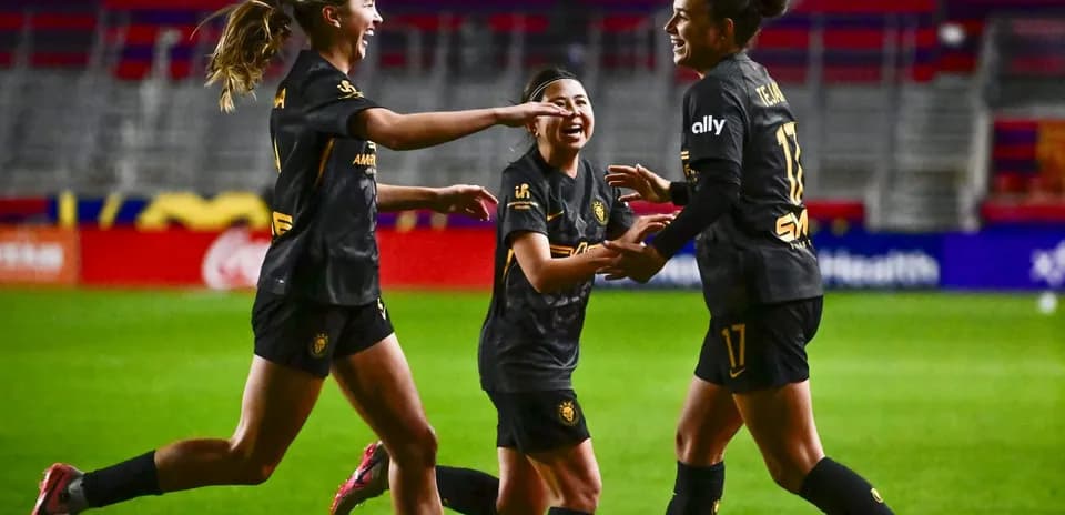 Players celebrating a goal during NWSL match