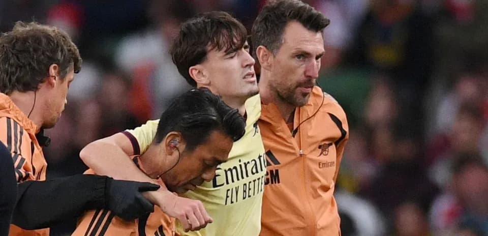 Player being assisted off the field by staff
