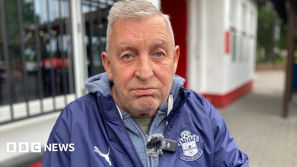 Man wearing Southampton FC jacket sitting outdoors