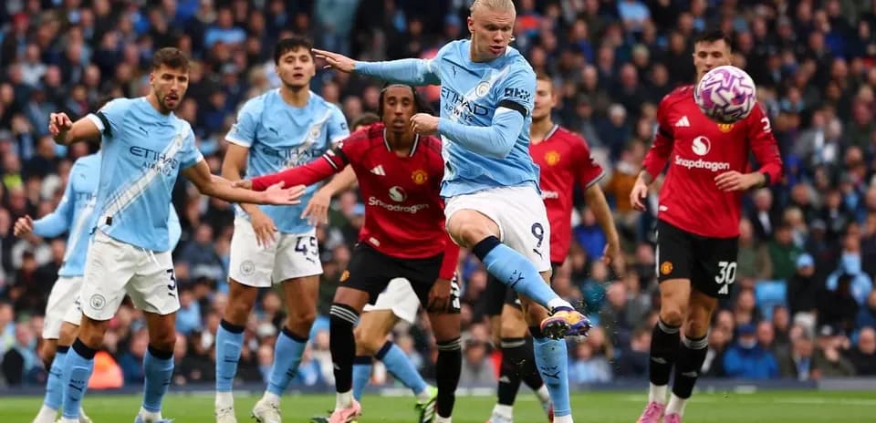 Erling Haaland striking the ball during Manchester derby