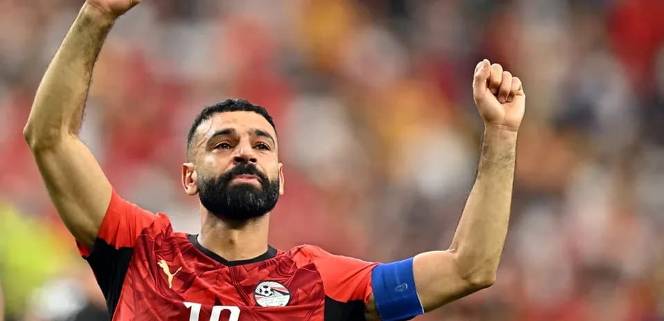 Player celebrating with raised arms in Egypt kit