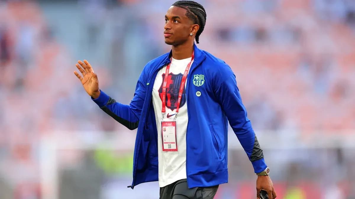 Player walking on field with team jacket and ID badge