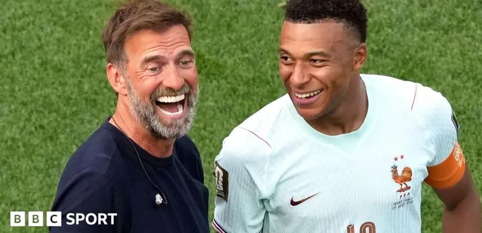 Two men smiling on the football pitch