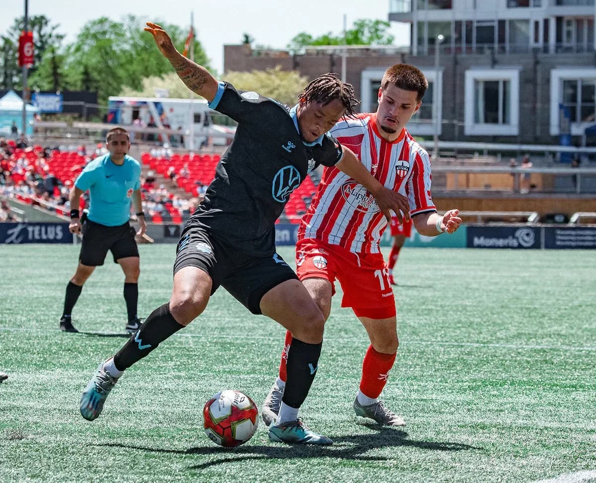 HFX Wanderers FC player tackling Atlético Ottawa player