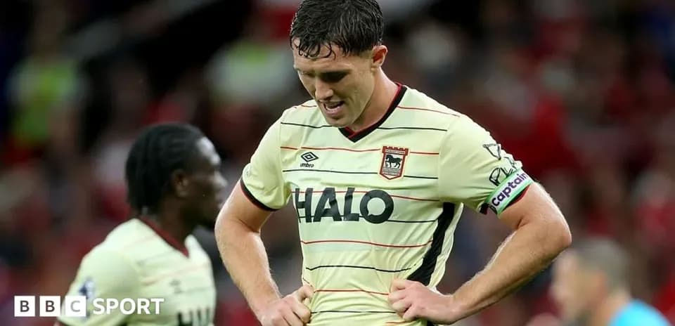 Player with captain's armband looking down in disappointment