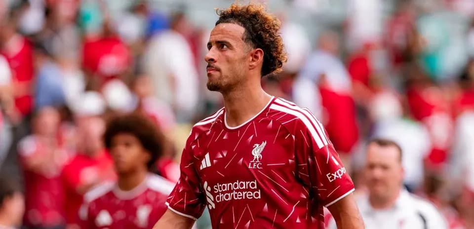 Player in Liverpool kit walking past fans