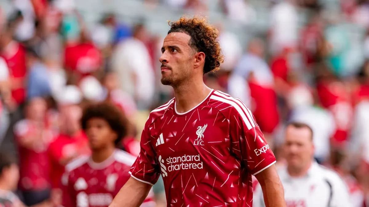 Player in Liverpool kit walking past fans