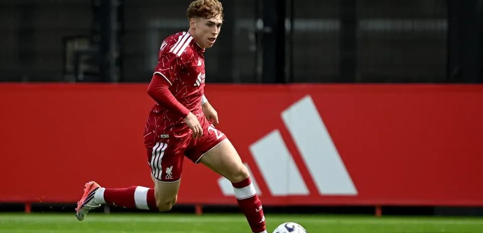Player in red kit running with soccer ball
