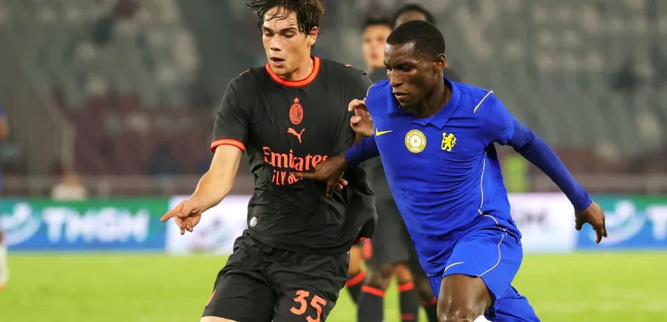 Players from AC Milan and Chelsea competing for the ball