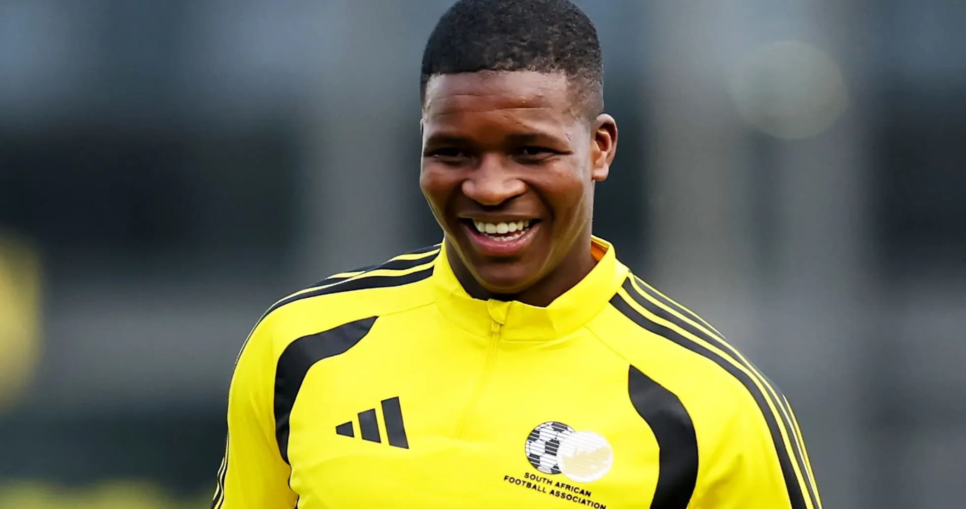 Player smiling during training session in yellow kit
