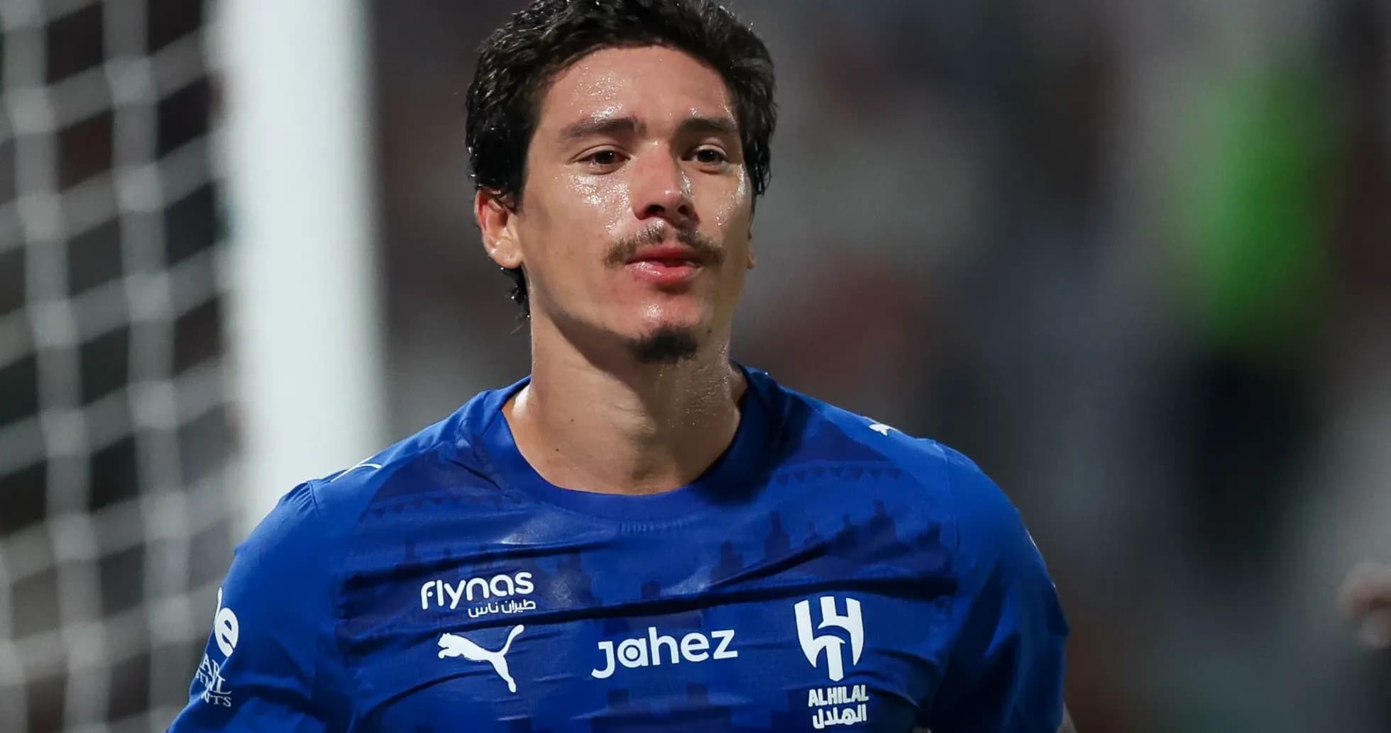 Player wearing blue jersey during match celebration