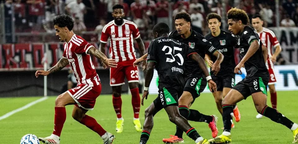 Olympiakos player dribbling past NEC Nijmegen defenders