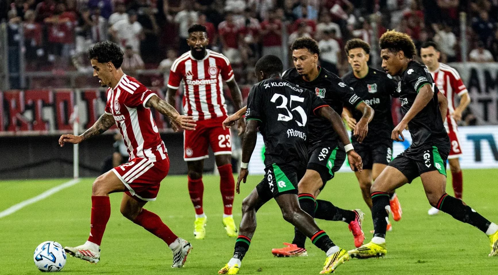 Olympiakos player dribbling past NEC Nijmegen defenders