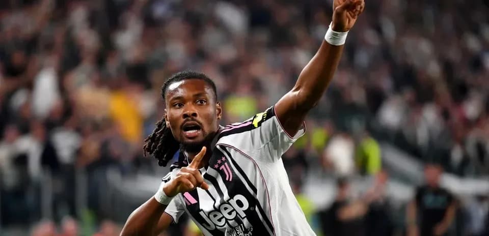 Player celebrating goal with finger raised in stadium