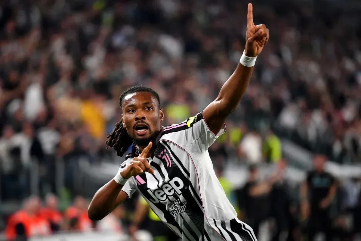 Player celebrating goal with finger raised in stadium
