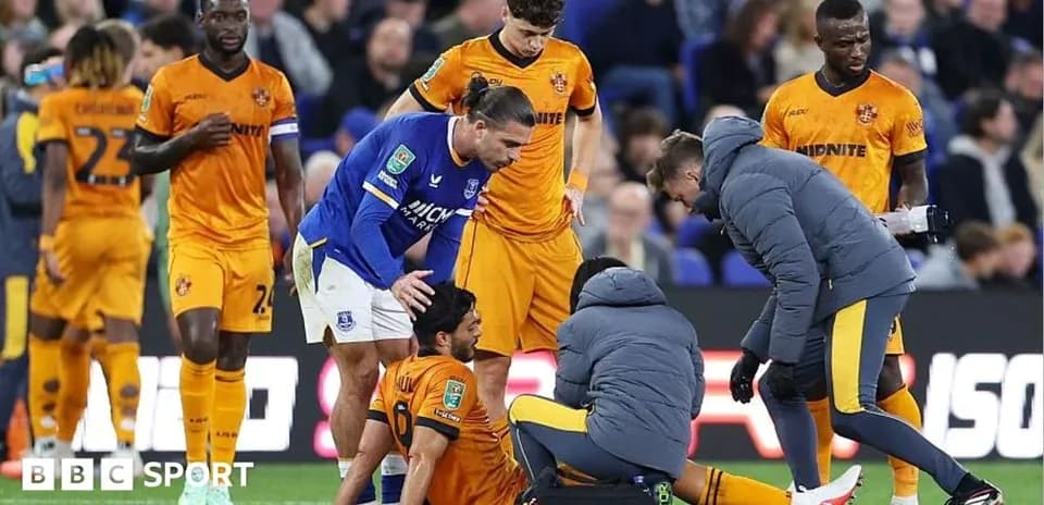 Players attending to an injured teammate on pitch